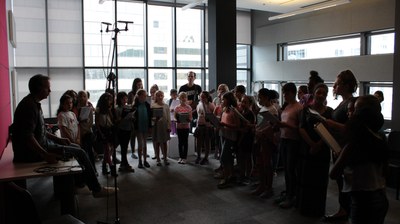 Tour with students from the École George-Étienne-Cartier A group of school children in a large meeting room with educators and researchers