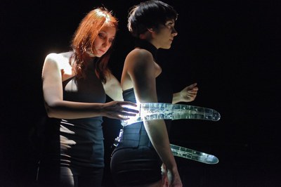 Two dancers manipulating motion-sensitive digital instruments during a performance of Les Gestes