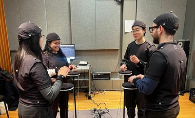 SynchMuse with four people around percussive plates wearing motion capture equipment