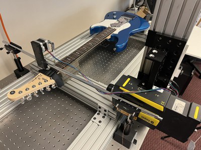 A guitar resting on an admittance measuring equipment system