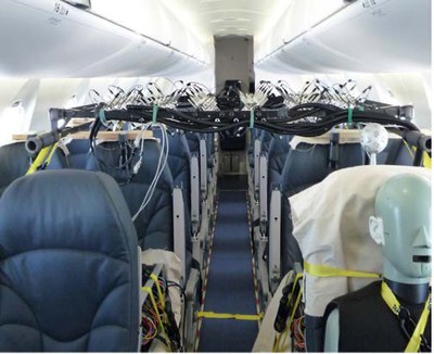 An aircraft cabin showing seats and the aisle with acoustic measurement equipment installed throughout