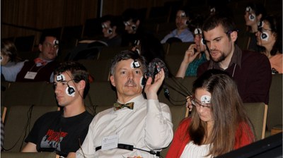 Projet CARS : des personnes assises dans un auditorium avec des capteurs fixés sur la tête
