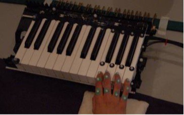 Interface clavier avec la main droite sur les touches, ainsi que des marqueurs de capture de mouvement sur la main et les touches